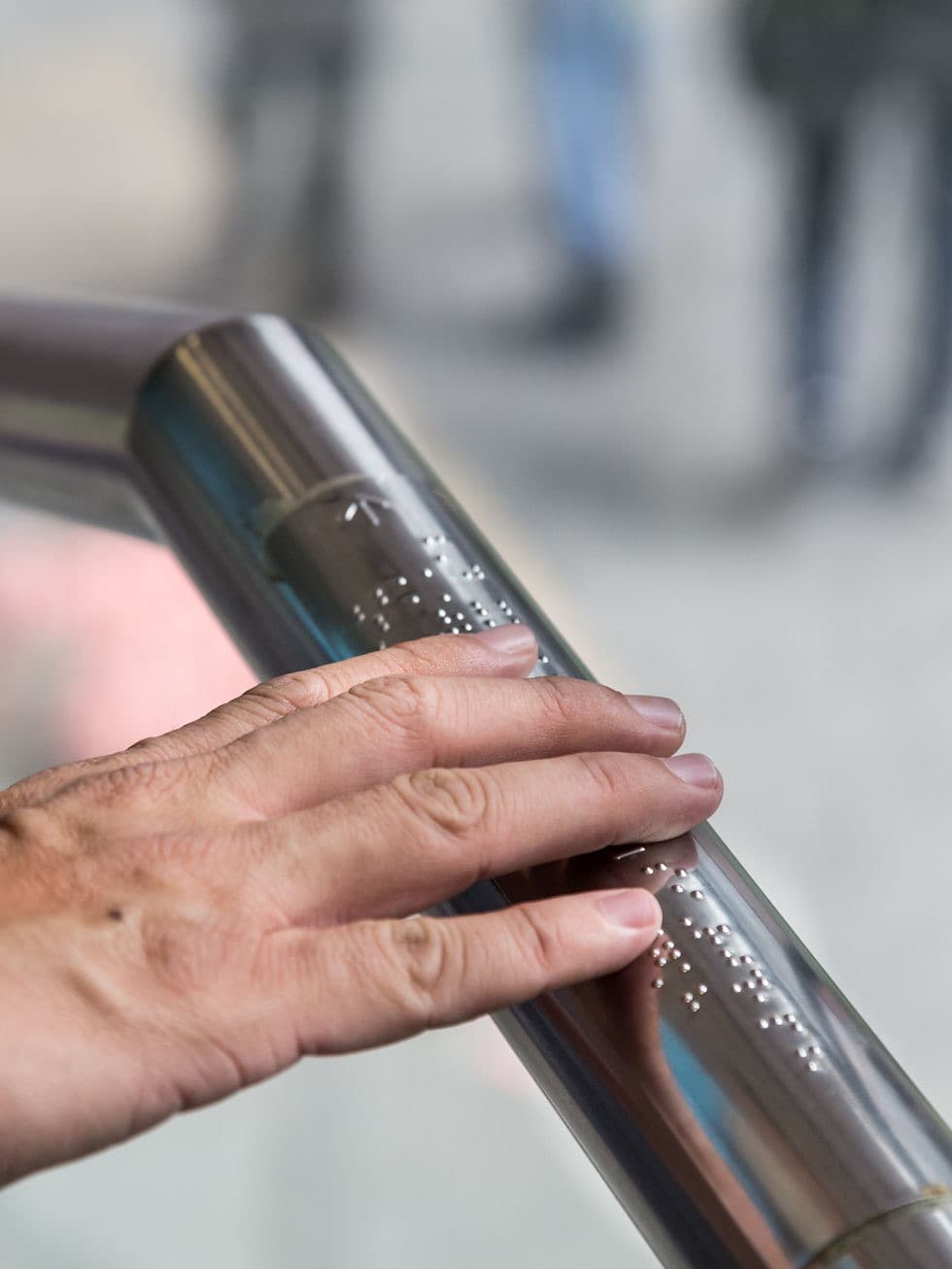 A braille inscription on a handrail